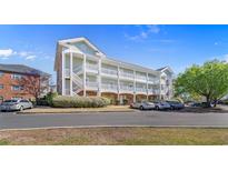 Inviting condo building featuring stairways and a parking lot with landscaping at 3935 Gladiola Ct. # 302, Myrtle Beach, SC 29588