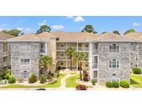 A charming condo complex featuring balconies, lush landscaping, and a well-maintained exterior at 4705 Wild Iris Dr. # 201, Myrtle Beach, SC 29577