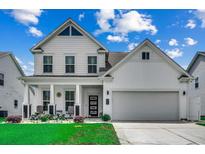 Charming two-story white home featuring a landscaped front yard and a two-car garage at 5013 Sassari St., Myrtle Beach, SC 29579