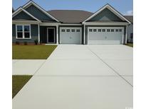Charming home featuring a two-car garage and well-manicured lawn at 519 Oak Landing Dr., Myrtle Beach, SC 29588