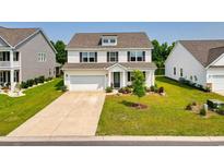 Charming two-story home with a well-manicured lawn and a classic white exterior at 560 Pier Ct., Longs, SC 29568