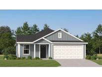 Charming single-story home featuring a gray exterior, manicured lawn, and attached two-car garage at 6366 Swainson Street Sw, Ocean Isle Beach, NC 28469