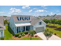 Charming home featuring dormer windows, a covered porch, and a two-car garage, set amidst a well-manicured lawn at 6378 Torino Lane, Myrtle Beach, SC 29572