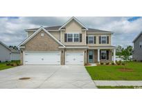 Two-story home with a two-car garage, brick and vinyl siding and a well-manicured front lawn at 7183 Shooting Star Way, Myrtle Beach, SC 29579