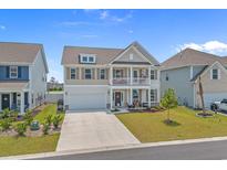 Charming two-story home featuring a covered porch, balcony, and a well-maintained front yard on a sunny day at 753 Enchantment Loop, Myrtle Beach, SC 29588