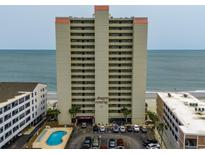 Oceanfront condo building with a pool and parking at 912 N Waccamaw Dr. # 904, Garden City Beach, SC 29576