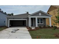 Charming single-story home featuring gray siding, a covered entrance, attached garage and a well-manicured front yard at 1043 Laconic Dr., Myrtle Beach, SC 29588