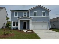 Two-story blue home featuring white trim, a two-car garage, and a well-manicured lawn at 1046 Laconic Dr., Myrtle Beach, SC 29588