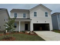 Charming two-story home with white siding, manicured lawn, attached garage, and a welcoming front porch at 1050 Laconic Dr., Myrtle Beach, SC 29588