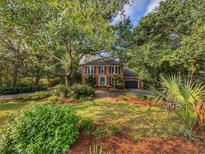 Beautiful brick home with mature trees and a manicured lawn in a serene setting at 1073 Crooked Oak Dr., Pawleys Island, SC 29585