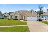 Charming single-story home featuring a well-manicured lawn, two-car garage, and inviting facade at 1149 6Th Ave. S, North Myrtle Beach, SC 29582