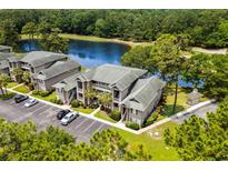 Beautiful condo community overlooking serene lake with lush landscaping, parking, and well-maintained buildings at 117 Pinehurst Ln. # 5-J, Pawleys Island, SC 29585