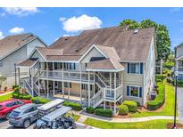 Inviting two-story condo with upper-level deck, manicured landscaping, and convenient parking at 1870 Auburn Dr. # 22A, Surfside Beach, SC 29575