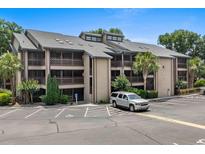 Multi-story condo building with balconies, parking, and landscaping on a bright, sunny day at 223 Maison Dr. # B-8, Myrtle Beach, SC 29572