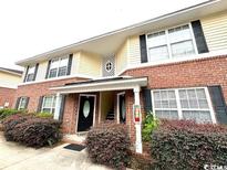 Charming two-story townhouse features a brick facade, black shutters, and a well-maintained lawn at 2407 James St. # 401, Conway, SC 29527
