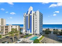 Coastal condo building features a swimming pool, parking, and overlooks an expansive beach with beautiful blue skies at 2609 South Ocean Blvd. # 702, North Myrtle Beach, SC 29582