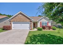 Charming brick and vinyl home with manicured lawn, two-car garage and inviting curb appeal on a sunny day at 266 Tall Palms Way, Little River, SC 29566