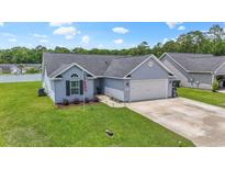 Charming single-Gathering home boasts a well-manicured lawn and attached two-car garage at 282 Foxpath Loop, Myrtle Beach, SC 29588