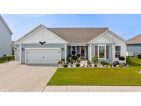 Charming single-story home with blue siding, a well-manicured lawn, and an attached two-car garage at 379 Mikita Dr., Surfside Beach, SC 29575