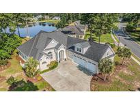 Stunning lakefront home features an elegant stone facade, a three-car garage, and a beautifully landscaped yard at 400 Summerwood Ct., Myrtle Beach, SC 29579