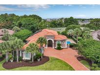 Expansive aerial view showcasing a landscaped property with a pool, brick driveway, and elegant home design at 434 Posada Dr., Myrtle Beach, SC 29572