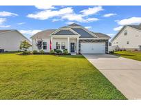Charming single-story home with a well-manicured lawn and a two-car garage at 447 Honeyhill Loop, Conway, SC 29526