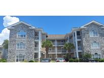 Multi-level condo building featuring charming architecture, balconies, and well-maintained landscaping at 4753 Wild Iris Dr. # 301, Myrtle Beach, SC 29577