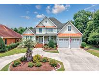 Charming two-story home with a well-manicured lawn, a two-car garage, and a welcoming front porch at 504 Sea Vista Ln., North Myrtle Beach, SC 29582