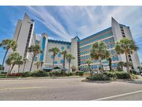 Beautiful exterior view of the condo building with blue accents and tropical landscaping at 7100 North Ocean Blvd. # 617, Myrtle Beach, SC 29577