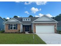 Charming single-story home with stone accents, white garage door, and a well-manicured lawn at 7180 Shooting Star Way, Myrtle Beach, SC 29579