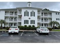 Three-story condominium building featuring reserved parking, manicured landscaping, and classic architectural details at 770 Charter Dr. # C4, Longs, SC 29568