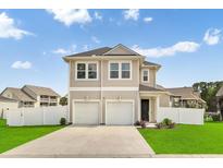 Inviting two-story home featuring double garages, manicured lawn, and charming curb appeal at 79 S Reindeer Rd., Surfside Beach, SC 29575