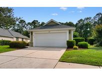 Attached one-car garage with white door, green siding, and well-maintained landscaping at 821 Laquinta Loop, Murrells Inlet, SC 29576