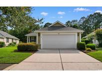 Well-maintained, one-story home with an attached two-car garage and manicured landscaping at 821 Laquinta Loop, Murrells Inlet, SC 29576