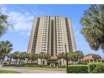High rise condo building exterior showing the entrance and lush landscaping at 8560 Queensway Blvd. # 106, Myrtle Beach, SC 29572