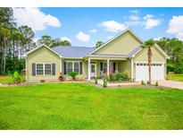 Charming single-story home with a lush green lawn, tidy landscaping, and a welcoming front porch at 1013 Happy Ln., Galivants Ferry, SC 29544