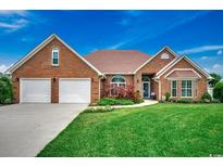 Charming brick home with a well-manicured lawn and attached two-car garage at 1017 Coral Reef Dr., North Myrtle Beach, SC 29582