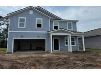 Two-story blue home with a front porch, unfinished landscaping, and a two-car garage at 1039 Laconic Dr., Myrtle Beach, SC 29588
