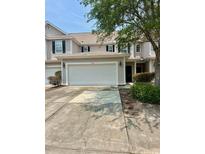 Tan two-story townhome with an attached two-car garage and a concrete driveway at 1048 Fairway Ln. # 1048, Conway, SC 29526