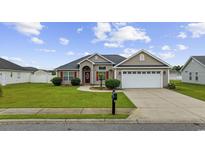 Charming single-story home with well-manicured lawn, red door, and two-car garage at 1205 Cymmer Ct., Conway, SC 29527