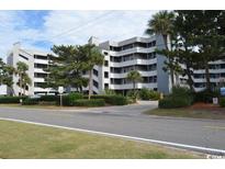A wide exterior shot showing the condo community and landscaping on a bright day at 1310 N Waccamaw Dr. # 102, Garden City Beach, SC 29576