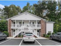 Charming condo featuring white siding, brick accents, and inviting double porches at 157 Egret Run Ln. # 523, Pawleys Island, SC 29585