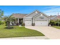 Charming home featuring a two-car garage, well-manicured lawn, and inviting front porch perfect for relaxing at 1833 Lake Egret Dr., North Myrtle Beach, SC 29582