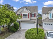 Charming two-story home featuring a two-car garage, well-manicured lawn, and red shutters adding a pop of color at 185 Fulbourn Pl., Myrtle Beach, SC 29579