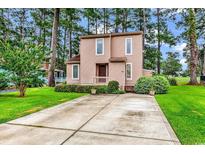 Charming two-story home with front yard, tidy landscaping, and long private driveway at 1880 Plantation Dr., Myrtle Beach, SC 29577