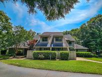 Charming multi-story home with well-maintained landscaping and mature trees under a bright, partly cloudy sky at 210 Westleton Dr. # 13-D, Myrtle Beach, SC 29572