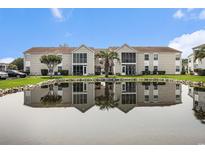 Exterior of charming condo building reflected in community pond with a well manicured lawn at 2257 Huntingdon Dr. # H, Myrtle Beach, SC 29575