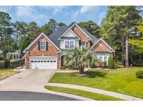 Charming two-story brick home with a manicured lawn, mature trees, and an attached two-car garage at 4232 Pointer Ct., Myrtle Beach, SC 29579