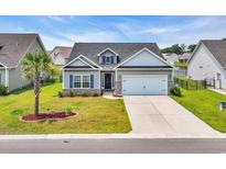 Charming single-story home with well-manicured lawn, two-car garage and lovely curb appeal at 446 Rycola Circle, Surfside Beach, SC 29575