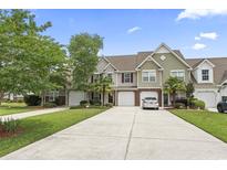 Charming townhomes feature attached garages, manicured lawns and mature trees under a bright blue sky at 592 Riverward Dr. # 592, Myrtle Beach, SC 29588